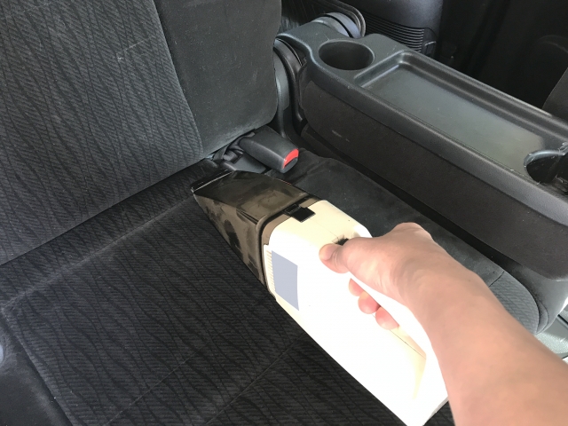 ハンディクリーナでシートを掃除している