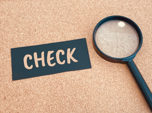 虫眼鏡でCHECKと書かれた木製ブロックを拡大している写真