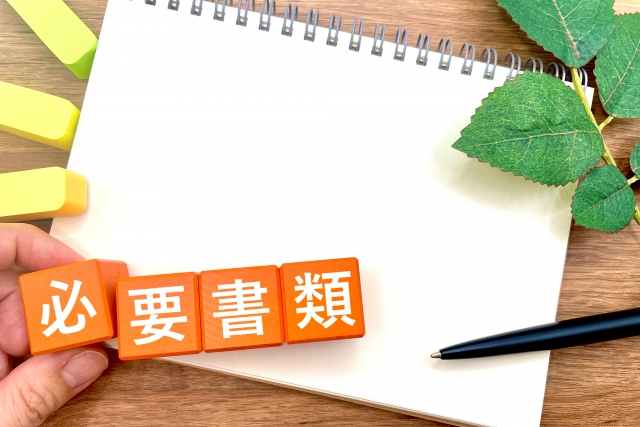 書類提出に必要な「要書類」と書かれたカードとノートのイメージ写真。手続きや申請を表現。