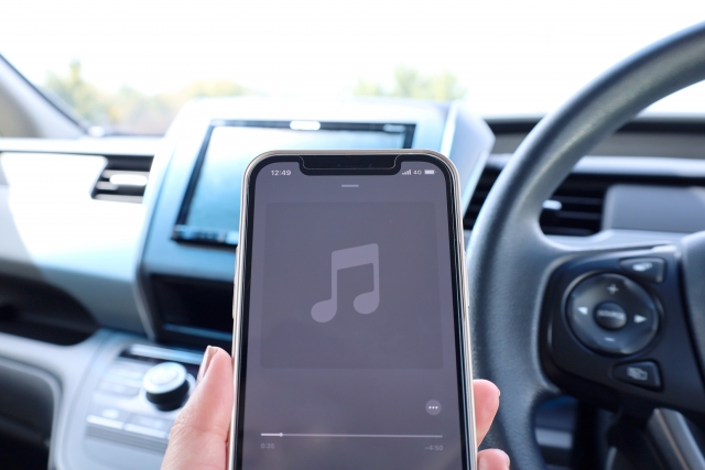 車内でスマートフォンを使って音楽を再生している様子