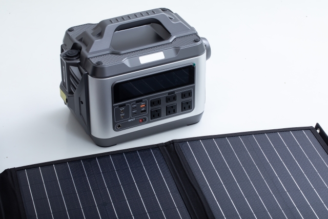 屋外でソーラーパネルを使ってポータブル電源を充電している様子