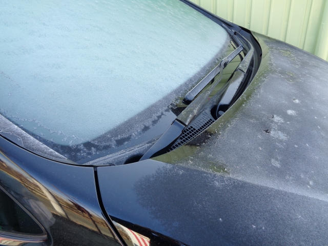 冬の朝にフロントガラスが凍りついた車の写真
