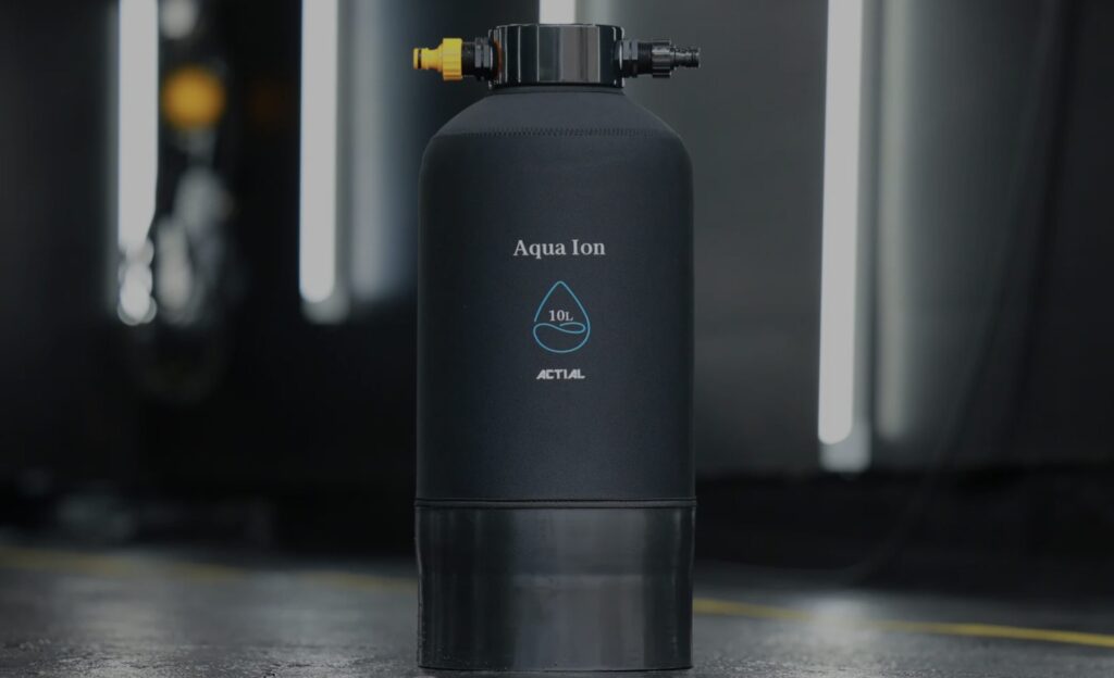 ACTIALの純水精製タンク「Aqua Ion 10L」の製品画像。黒いボトル型デザインで両端に接続口が付いている。