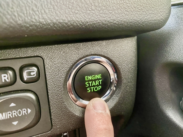 指でエンジンスタートボタンを押している様子を撮影した写真です。