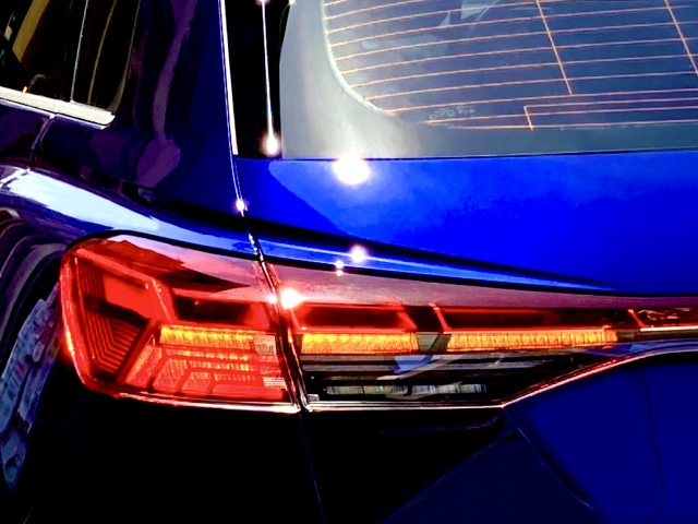 夜間に赤く点灯したテールランプを近距離から撮影した写真です。